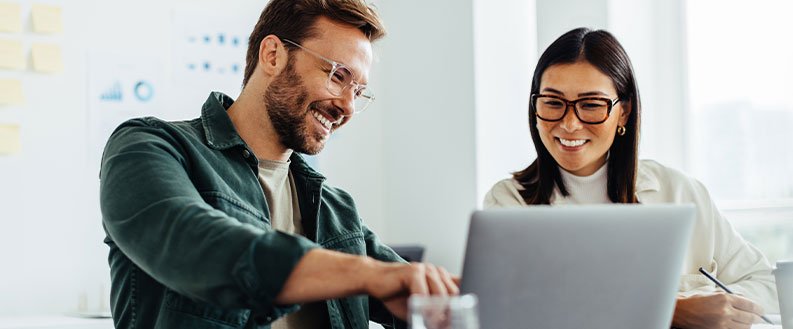 two people working together on a laptop