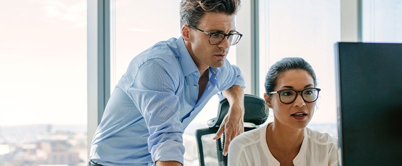 two coworkers looking at computer